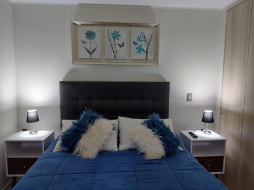 a bedroom with a blue bed with blue and white pillows at Departamento con vista al mar en Condominio Lagunamar in Las Cruces