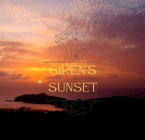 a sunset with a girl standing in the water at Sirens Sunset Peaceful Retreat with stunning sea views, 5 minutes from Porth Beach in Newquay