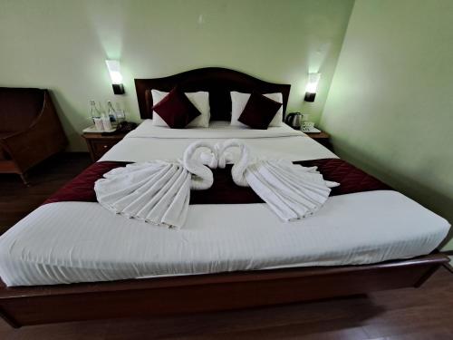 a bed with two swans made to look like wings at Hotel Preethi Classic Towers in Ooty