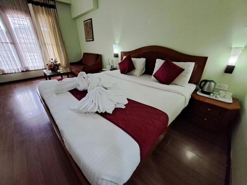 a hotel room with two beds with towels on them at Hotel Preethi Classic Towers in Ooty