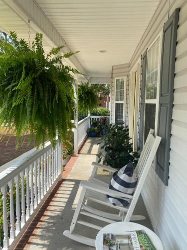 een veranda met een witte schommelstoel op een huis bij Suite Melissa's Pinehurst Country Club #6 Private Room and Bath in Pinehurst