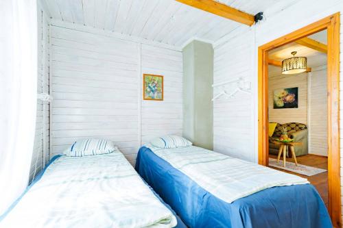 two beds in a room with white walls at Domek letniskowy nad jeziorem in Łąck
