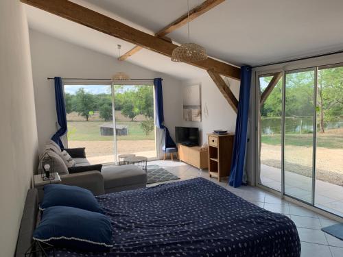 a bedroom with a bed and a couch and a window at Petite maison in Gabarret
