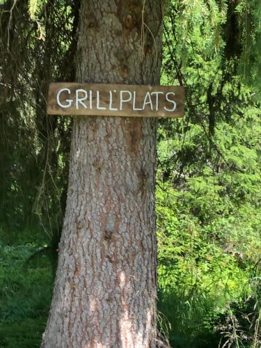 a sign on a tree in a forest at Fjällgården Grövelsjön Lillstugan in Grövelsjön