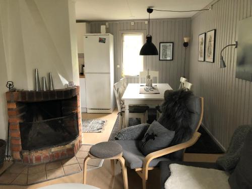 a living room with a chair and a fireplace at Fjällgården Grövelsjön Lillstugan 