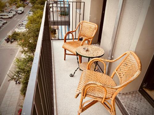 two wicker chairs and a table on a balcony at Brilliant Apartments in Berlin