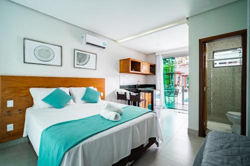a bedroom with a large bed with blue pillows at Escarpas Eco Village in Capitólio