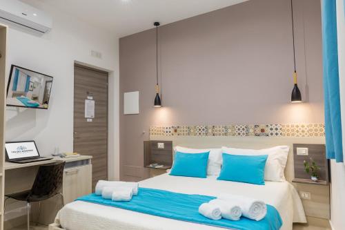 a bedroom with a bed with blue pillows and a desk at Casa dell'Aromatario b&b in Sciacca