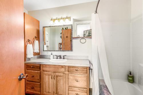 een badkamer met een wastafel, een spiegel en een bad bij Harborside Retreat in Vashon