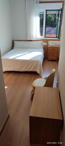 a bedroom with a bed and a desk and a chair at Hotel Brisa del Mar in O Grove