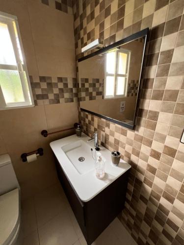 a bathroom with a sink and a mirror at Chalet en La Barrosa, Piscina+BBQ+Grifo de Cerveza in Chiclana de la Frontera
