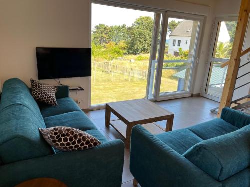 a living room with two blue couches and a table at Ty Koad in Lanmodez