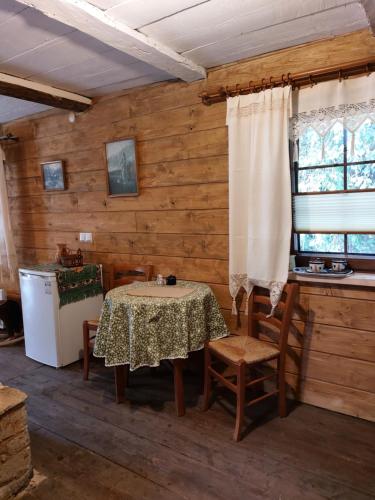 a dining room with a table and chairs and a window at Agroturystyka LipoweWzgórze domek Antek in Tereszpol