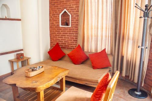 a living room with a couch with red pillows at New Orleans Apartment in Kathmandu