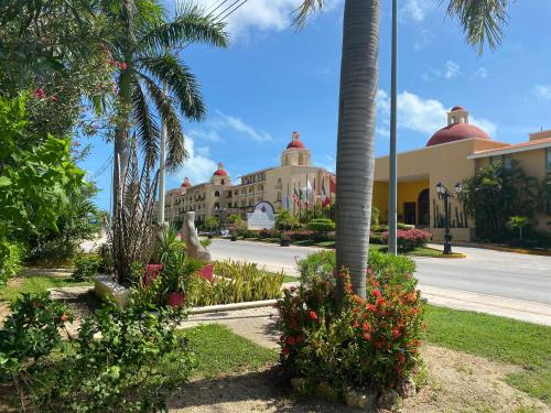 a building with palm trees and flowers in front of a street at Tropical apartment in Cancún