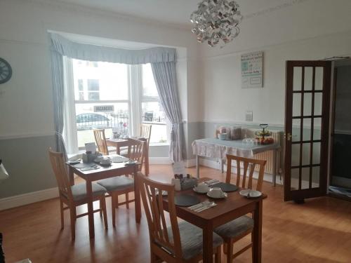 a dining room with a table and chairs and a window at No 6 Quality Guesthouse in Llandudno