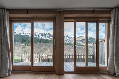 a room with sliding glass doors with a view of mountains at Chalet le Bonheur in Méribel