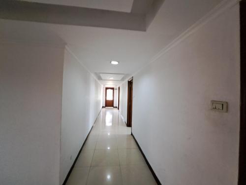 an empty hallway with white walls and a door at Hotel Preethi Classic Towers in Ooty