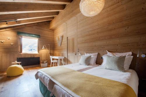 a bedroom with a large bed in a wooden room at Chalet le Bonheur in Méribel