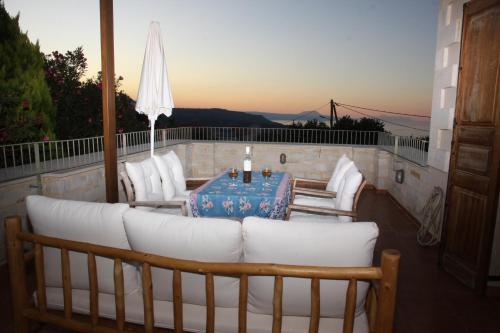 a patio with a couch and a table on a balcony at Aloe & Lotus Villas in Prinés