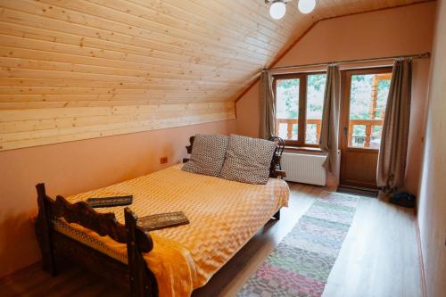 1 dormitorio con 1 cama en una habitación de madera en Садиба над потоком, en Lumshory