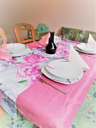 a pink table with plates and wine glasses on it at Appartement Jakalar in Vils
