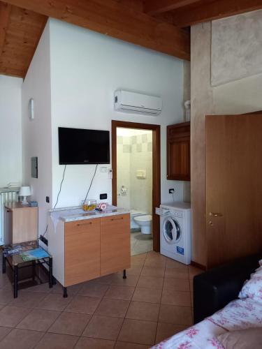 a living room with a kitchen with a washing machine at Appartamento Fiordaliso 2 in Montichiari