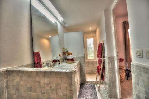 a large bathroom with a tub and a sink at Charmante Maison au Coeur de l'Oasis in Casablanca