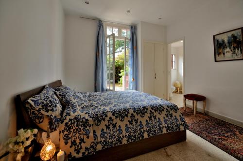 a bedroom with a bed with a blue and white comforter at Charmante Maison au Coeur de l'Oasis in Casablanca