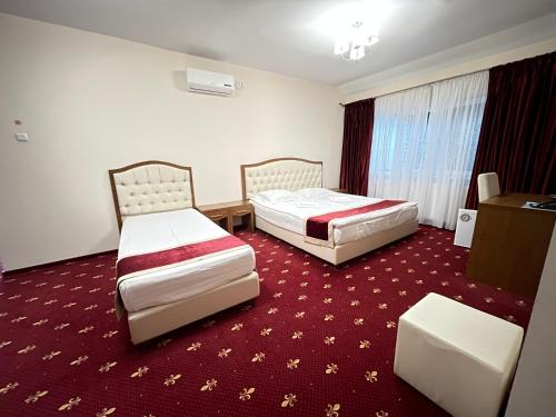 a hotel room with two beds and a table at Hostel Paltinis in Hunedoara