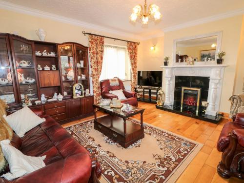 a living room with a couch and a fireplace at Derriens Farmhouse in Enniskillen