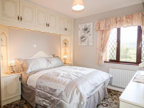 Un dormitorio con una cama grande y una ventana en Derriens Farmhouse, en Enniskillen