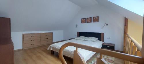 ein Schlafzimmer mit einem Bett, einer Kommode und einer Treppe in der Unterkunft Nostalgija2 in Nida