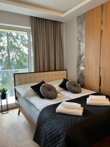 um quarto com 2 camas com almofadas e uma janela em Family & Business Elegant Apartments ul Lotnicza Centrum Galeria Korona - 1 Bedroom, Terrace, Air Conditioning, Garage - NEW! em Kielce
