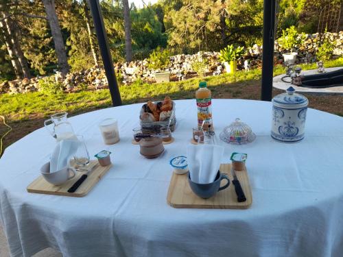 una mesa con un mantel blanco con tazas y utensilios en CHEZ VIVIANE en Celles-sur-Belle