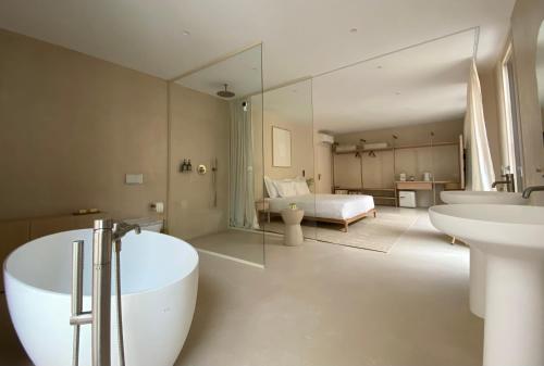 een badkamer met een bad, 2 wastafels en een bed bij Olive studios in Zadar