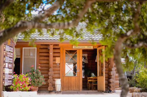 een houten hut met een deur en een bord erop bij Logos hotel in Yad Hashmona in Yad Hashmona