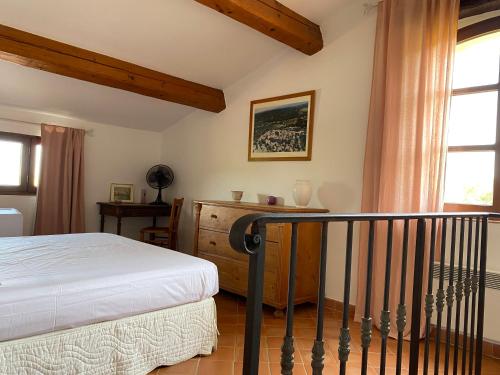 ラマチュエルにあるFERME DU MOULIN ROUX- 2 spacieux appartements- 2cbres chacun- Authentique ferme provençale- RAMATUELLEのベッドルーム1室(ベッド1台、デスク、窓付)