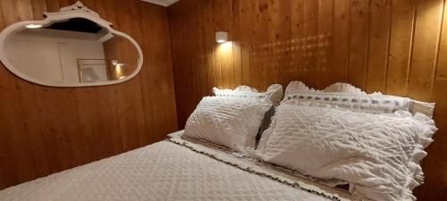 a bedroom with a bed with white pillows and a mirror at Casa da Pena in Mondim de Basto