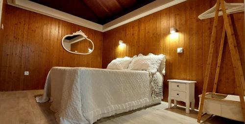 a bedroom with a bed in a wooden wall at Casa da Pena in Mondim de Basto