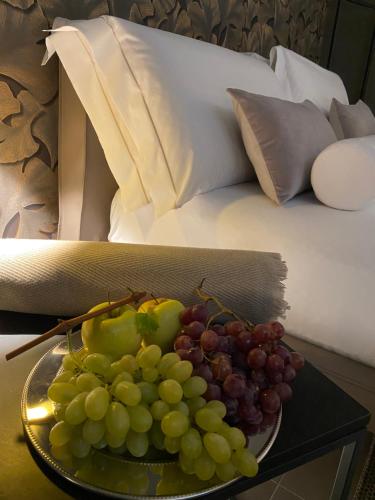 un piatto di uva su un tavolo accanto a un letto di DIMORA1934 Relax&Comfort a Tirano