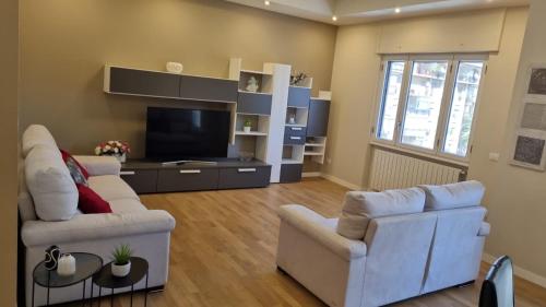 een woonkamer met twee witte banken en een televisie bij Dudi Apartment in Palermo