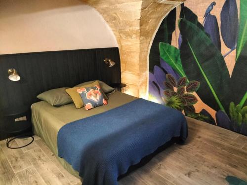 a bedroom with a bed with a blue blanket at Maison de village familiale Pont du Gard, toit terrasse, barbecue, Fibre in Vers Pont du Gard
