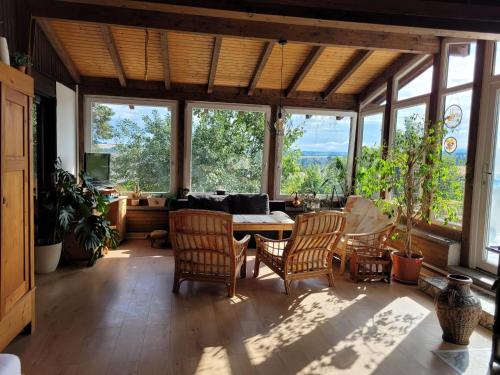 a living room with a table and chairs and windows at Ruheidylle Weitblick in Kleinich
