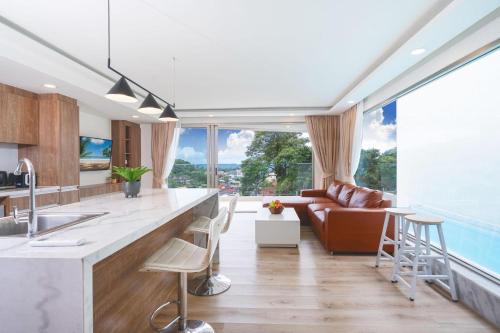 a kitchen and living room with a couch at seaview villa private swimming pool in Karon Beach
