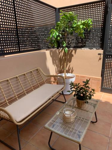 a bench and a table and potted plants on a balcony at Villa View Candesol con Jacuzzi privado in Puerto de Santiago