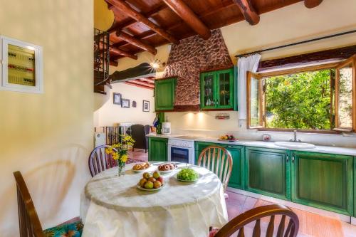 eine Küche mit grünen Schränken und einem Tisch mit Obst darauf in der Unterkunft Ifigenia Lux MAISONETTE in oldtown and Villas in theriso vilage 14 km outside of chania in Chania