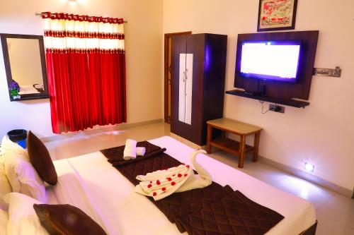 a living room with a couch and a television at SS Silver Oaks Resort in Yercaud
