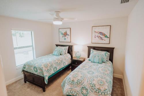 a bedroom with two beds and a window at The Basilican in Cape Coral