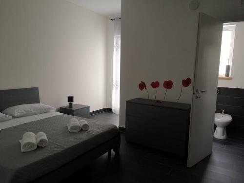 1 dormitorio con 1 cama y flores rojas en la pared en B&B Roseal, en Brusciano
